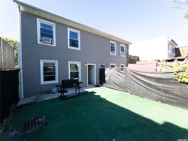 back of property with cooling unit, a patio area, and a lawn