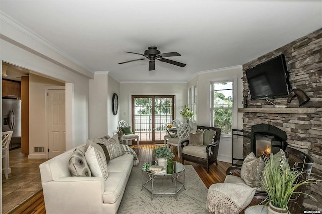 9 N Bayles Ave, Port Washington, NY 11050 - living room with dark hardwood / wood-style flooring, a stone fireplace, ceiling fan, and crown molding