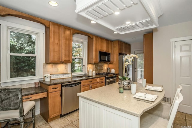 9 N Bayles Ave, Port Washington, NY 11050 - kitchen featuring decorative backsplash, a kitchen breakfast bar, stainless steel appliances, sink, and stone countertops