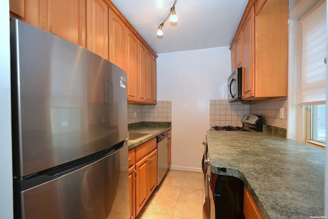 kitchen featuring light tile patterned floors, appliances with stainless steel finishes, and tasteful backsplash