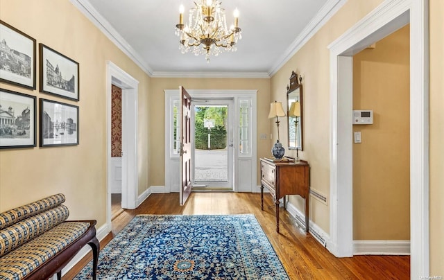 entryway with a notable chandelier, wood-type flooring, and crown molding