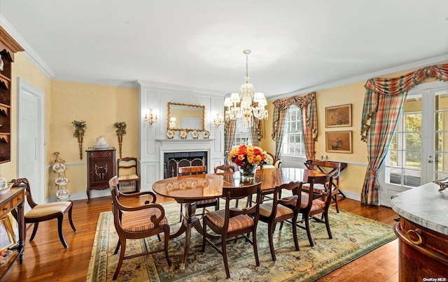 dining space with hardwood / wood-style flooring, a wealth of natural light, and ornamental molding