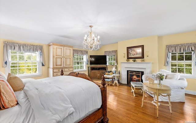 bedroom featuring multiple windows, a chandelier, and light wood-type flooring