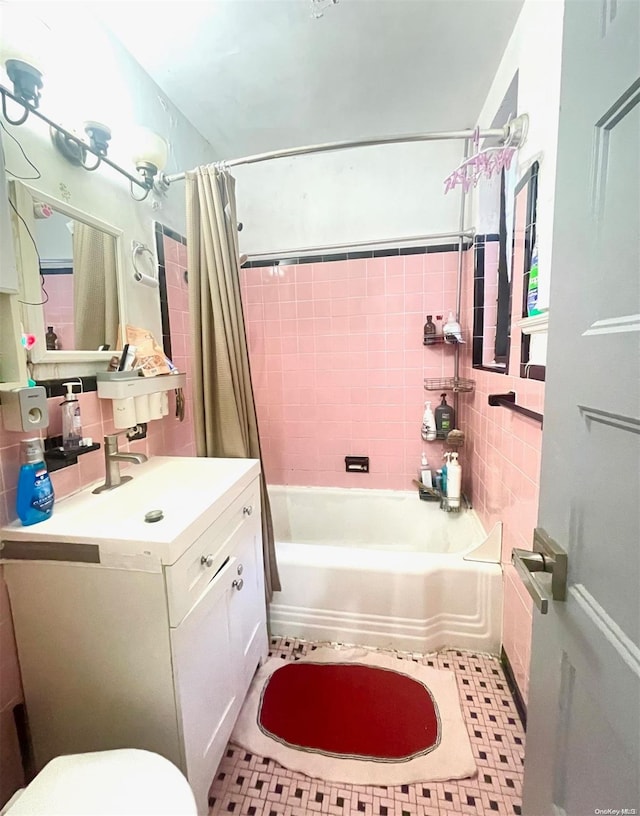 full bathroom featuring toilet, decorative backsplash, shower / bath combo with shower curtain, vanity, and tile walls