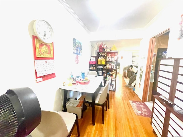 dining area with light hardwood / wood-style floors and ornamental molding