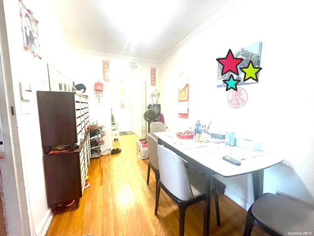 dining space featuring crown molding and light hardwood / wood-style flooring