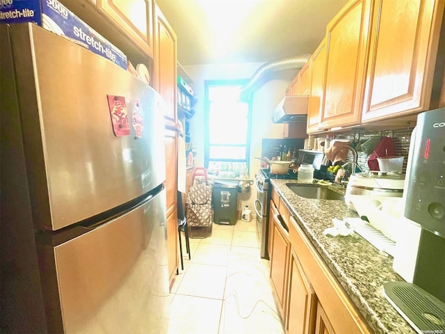 kitchen with sink, stainless steel appliances, and dark stone counters