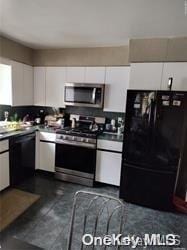 kitchen featuring backsplash, white cabinetry, and black appliances