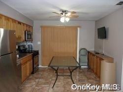 159-29 92nd St, Howard Beach, NY 11414 - kitchen featuring appliances with stainless steel finishes, brown cabinets, and ceiling fan