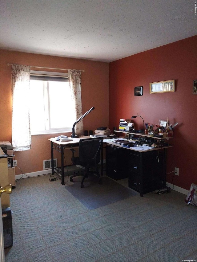 home office featuring light carpet and a textured ceiling