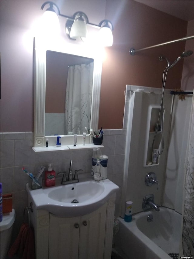 full bathroom with vanity, tub / shower combination, tile walls, and toilet