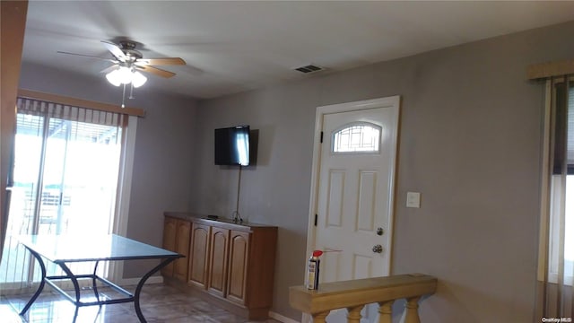 foyer entrance with ceiling fan