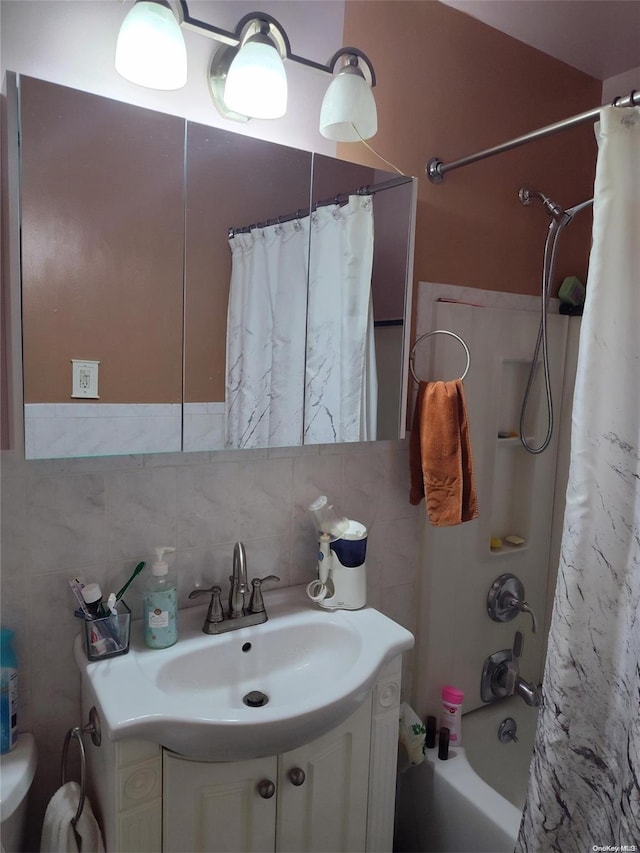 full bathroom with vanity, backsplash, toilet, tile walls, and shower / tub combo