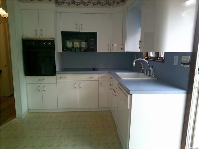 kitchen with white cabinetry, sink, and black appliances