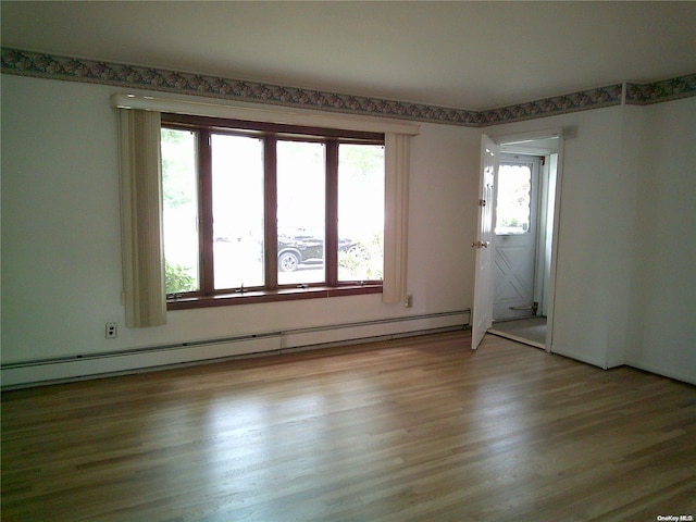 spare room with light hardwood / wood-style floors and a baseboard heating unit