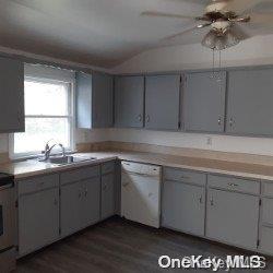 kitchen with stove, dark wood-type flooring, white dishwasher, sink, and gray cabinets