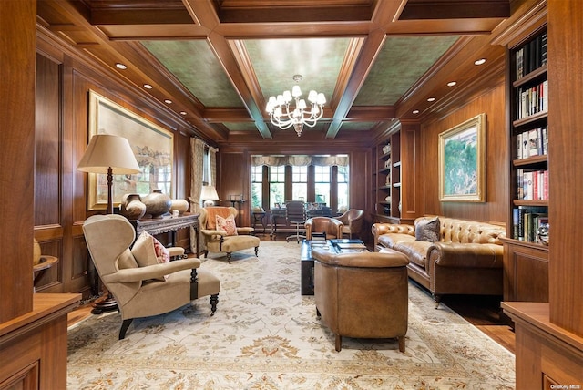 sitting room with ornamental molding, coffered ceiling, beamed ceiling, a chandelier, and wood walls