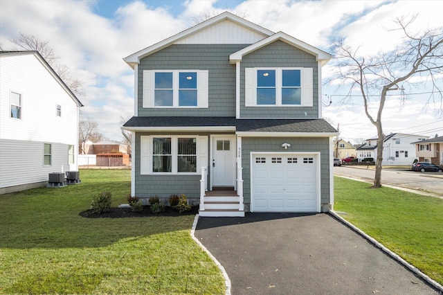 view of front of house featuring central AC unit, a garage, and a front lawn