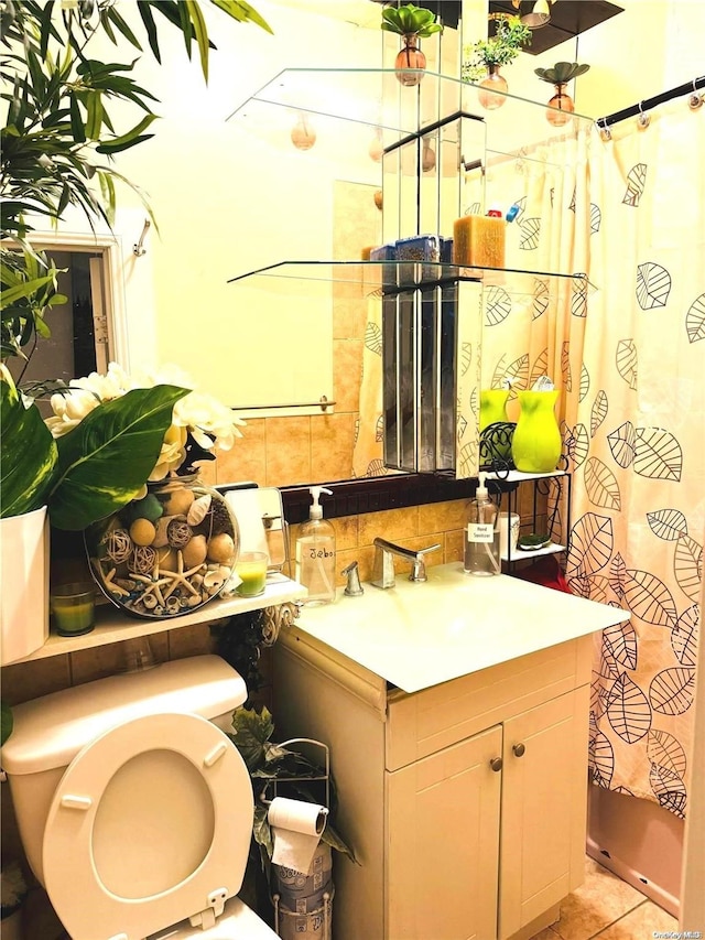 bathroom featuring tile patterned flooring, vanity, toilet, and tasteful backsplash