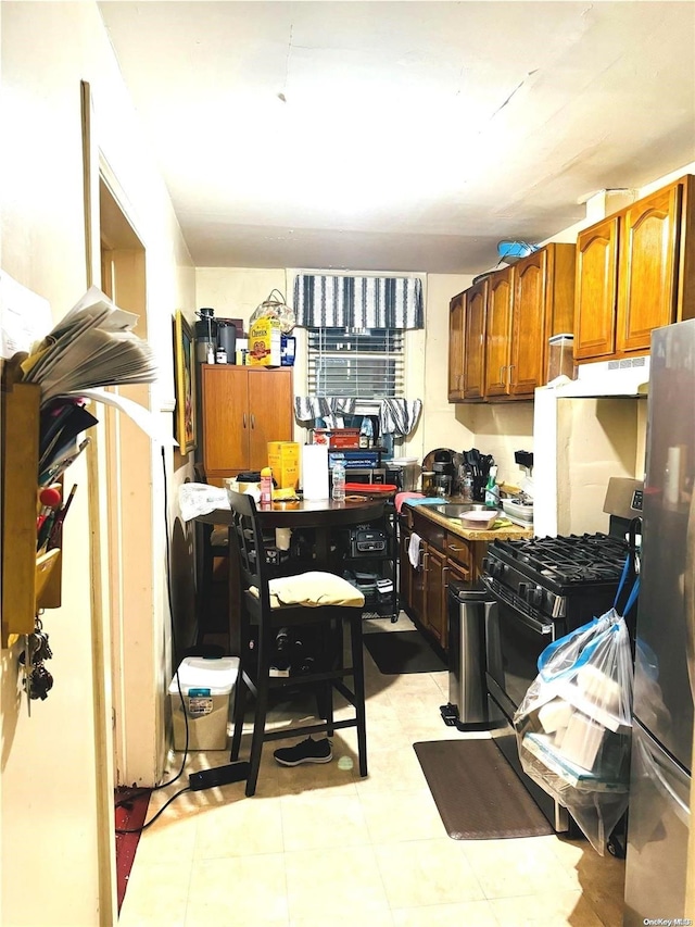 kitchen featuring gas stove and stainless steel refrigerator