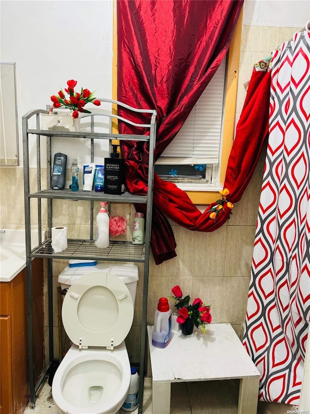 bathroom featuring toilet and tile walls