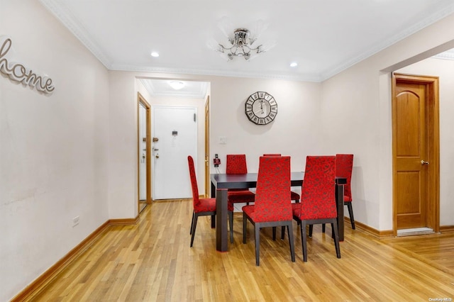 dining space with crown molding, light hardwood / wood-style floors, and an inviting chandelier