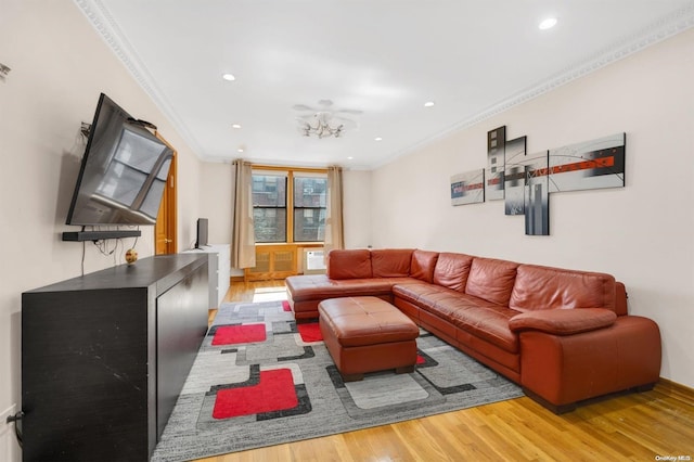 living room with a chandelier, light wood-type flooring, and crown molding