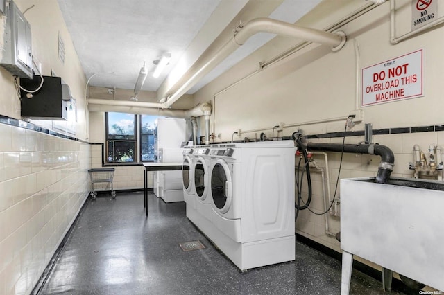 108-50 62nd Dr Unit 3F, Forest Hills, NY 11375 - laundry room featuring washing machine and clothes dryer and tile walls