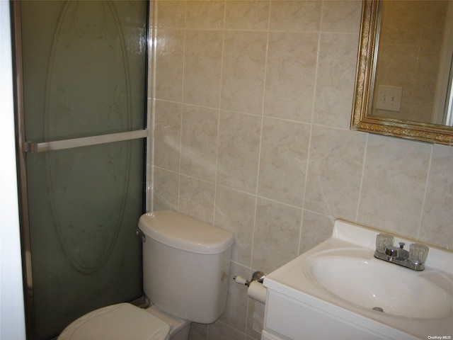 bathroom featuring an enclosed shower, vanity, toilet, and tile walls