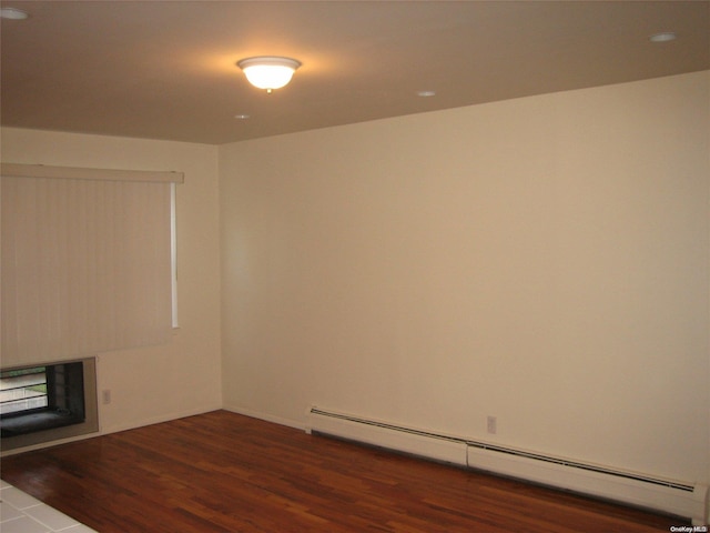 unfurnished room featuring dark wood-type flooring and a baseboard radiator