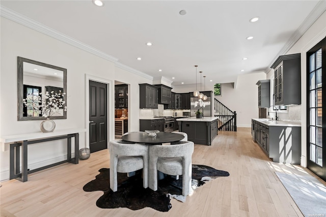 dining room with light wood finished floors, stairs, ornamental molding, and recessed lighting