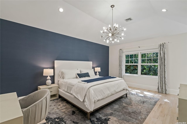 bedroom featuring lofted ceiling, recessed lighting, an accent wall, wood finished floors, and baseboards