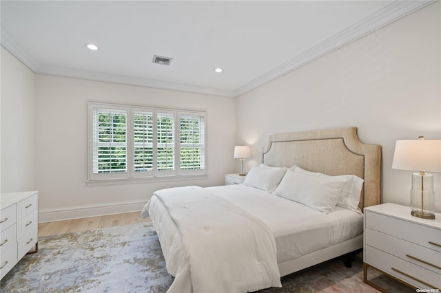 bedroom featuring baseboards, wood finished floors, visible vents, and crown molding