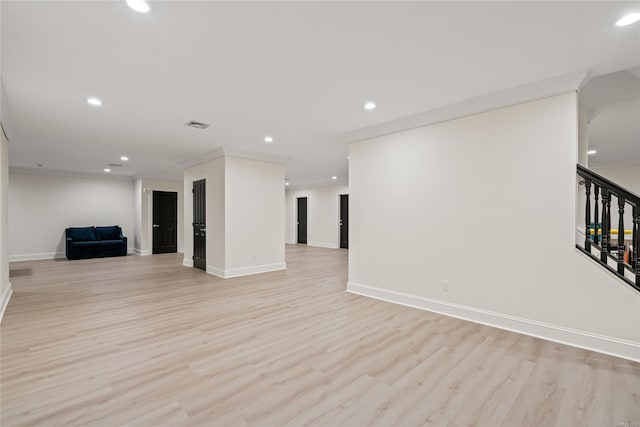 spare room featuring light wood-type flooring, recessed lighting, crown molding, and stairs