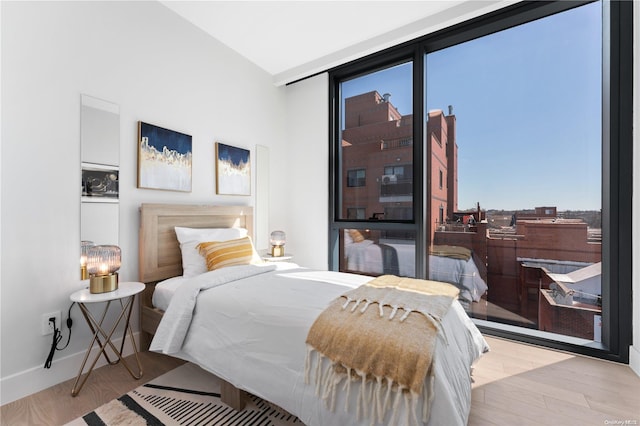 bedroom with multiple windows and light wood-type flooring