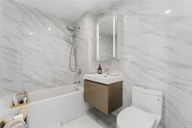 full bathroom with vanity, tiled shower / bath combo, tile walls, and toilet