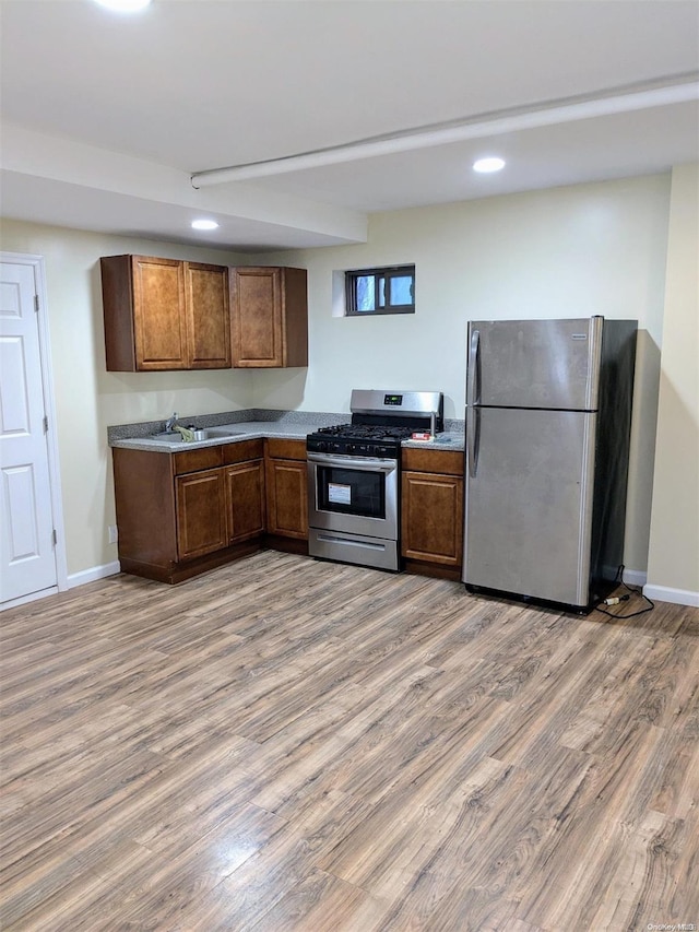 kitchen with appliances with stainless steel finishes, sink, and wood-type flooring