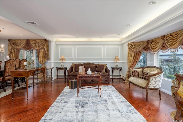 living area featuring dark hardwood / wood-style flooring, a baseboard heating unit, and a notable chandelier