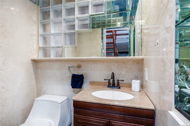 bathroom featuring vanity, tile walls, and toilet