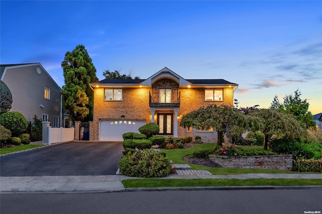 view of front of property featuring french doors, a balcony, and a garage