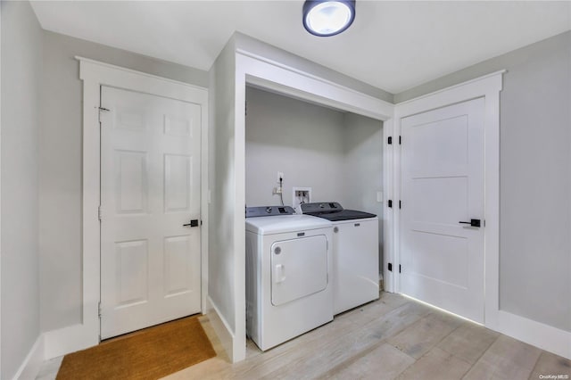 laundry room featuring washing machine and clothes dryer and light wood-type flooring