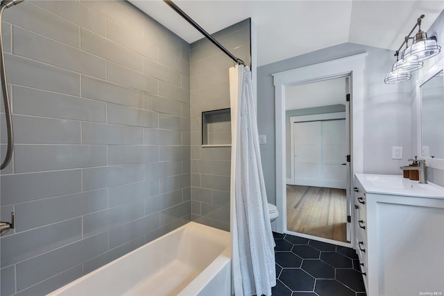 full bathroom with vaulted ceiling, toilet, shower / tub combo with curtain, vanity, and hardwood / wood-style flooring