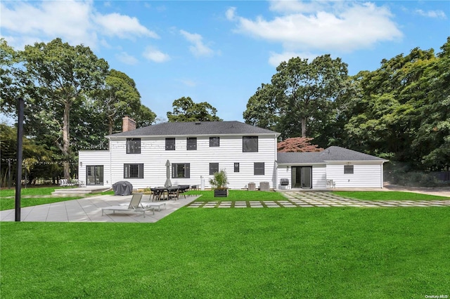 rear view of house with a yard and a patio