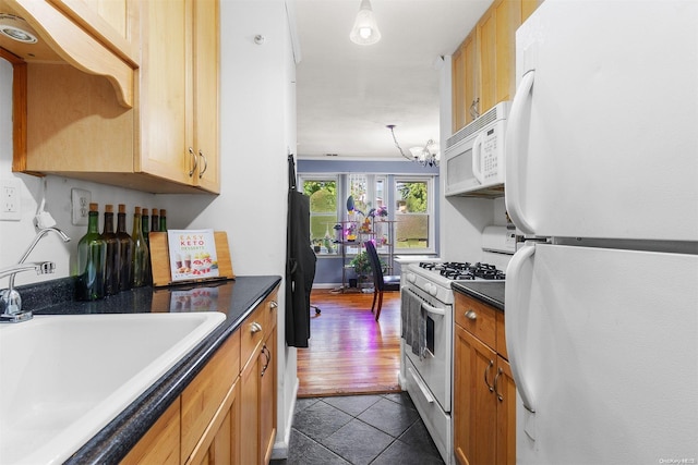 kitchen with white appliances, an inviting chandelier, dark wood-type flooring, and sink