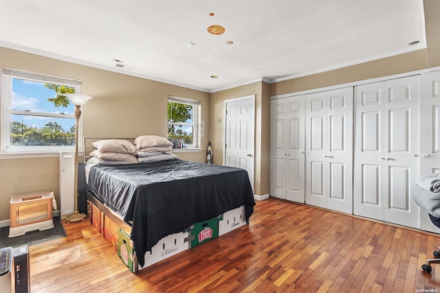 bedroom with ornamental molding and hardwood / wood-style flooring