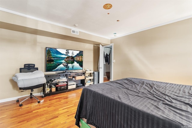 bedroom featuring wood-type flooring and crown molding