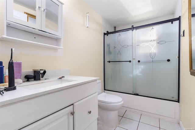 full bathroom with tile patterned floors, combined bath / shower with glass door, toilet, and vanity