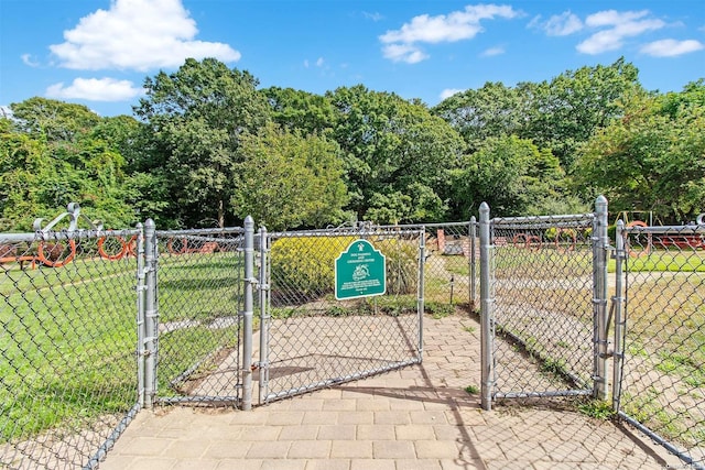 view of gate with a lawn