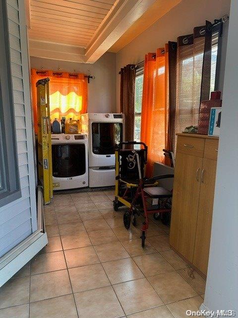 interior space featuring washer / clothes dryer, light tile patterned floors, and wood ceiling