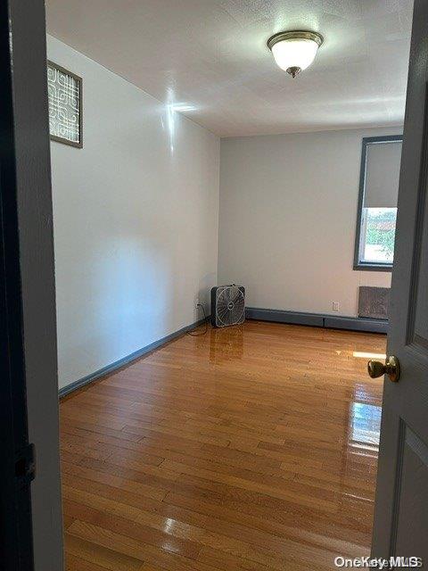 unfurnished room with wood-type flooring